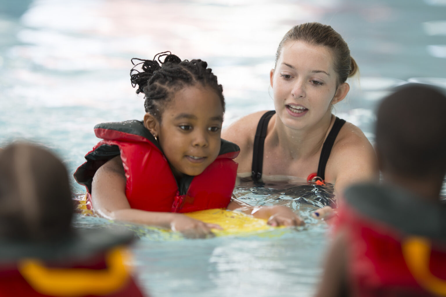 A child with autism engaging in aquatic therapy, floating on their back with arms outstretched in a pool, surrounded by gentle water movements.